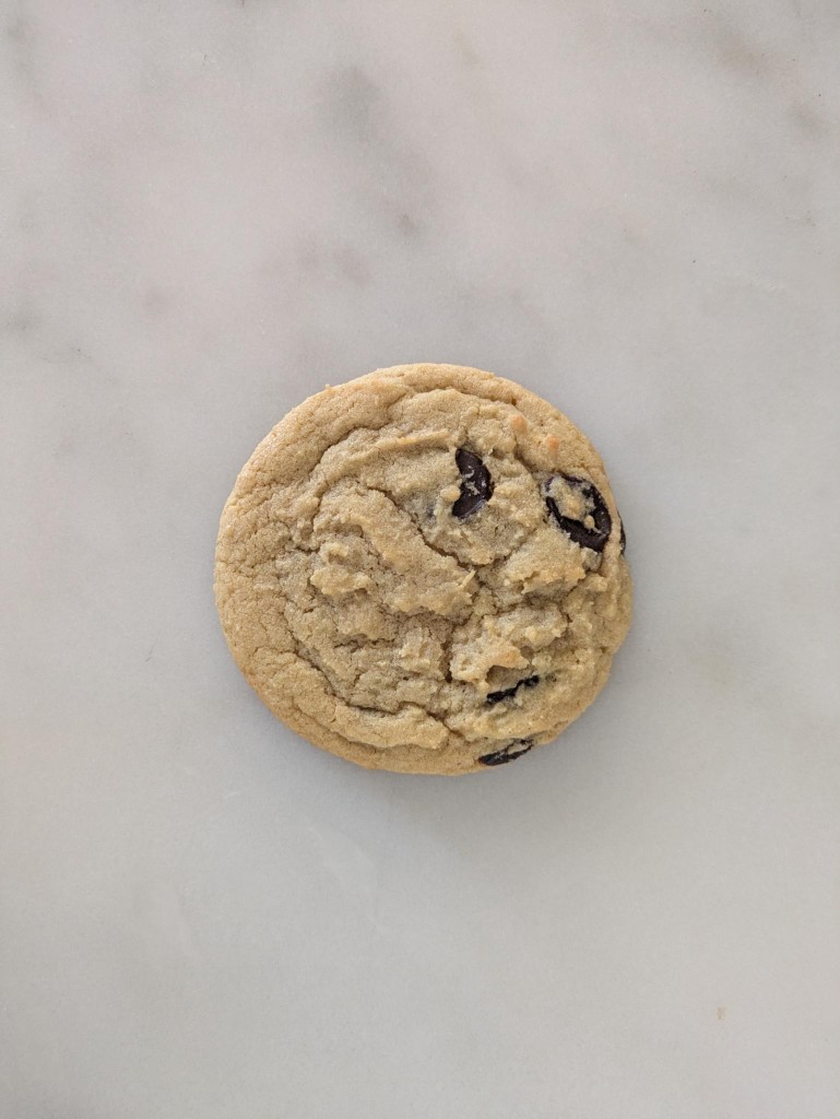 A single chocolate chip cookie on marble